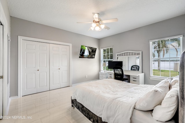 bedroom with ceiling fan, a textured ceiling, and a closet