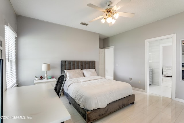 bedroom with ensuite bath, ceiling fan, and light tile patterned floors