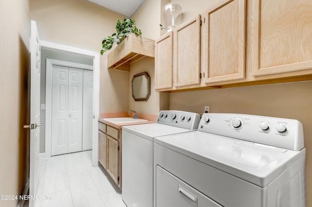 laundry room featuring washing machine and dryer, sink, and cabinets