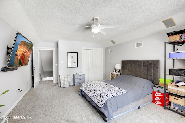 carpeted bedroom featuring vaulted ceiling, ceiling fan, a closet, and a textured ceiling