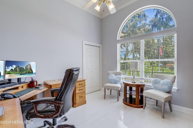 office area featuring ceiling fan, a healthy amount of sunlight, ornamental molding, and a high ceiling