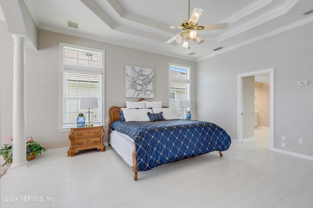 bedroom featuring ceiling fan, a raised ceiling, ornamental molding, and ornate columns