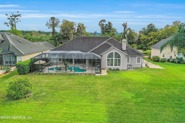 back of property featuring a lawn, glass enclosure, and a patio area