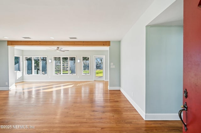 unfurnished room featuring ceiling fan, light hardwood / wood-style flooring, and beamed ceiling