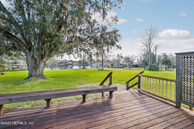 wooden deck featuring a lawn and a water view