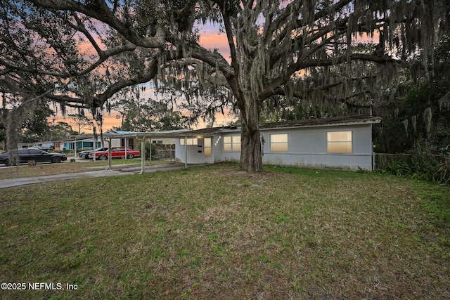 view of front facade with a lawn and a carport