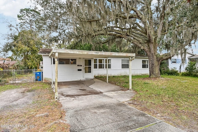 single story home featuring a front lawn and a carport