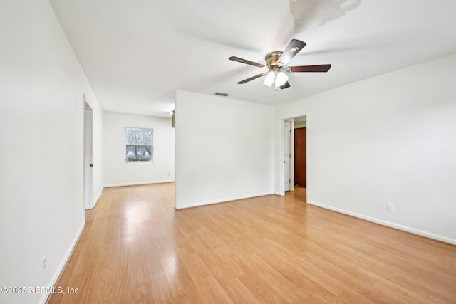 empty room with ceiling fan and light hardwood / wood-style flooring