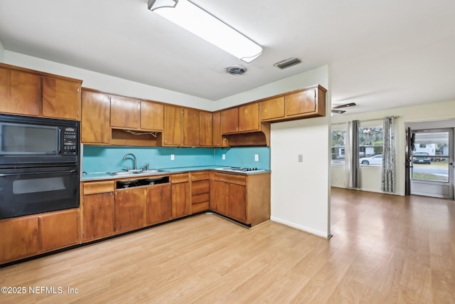 kitchen featuring light hardwood / wood-style floors, sink, and black appliances