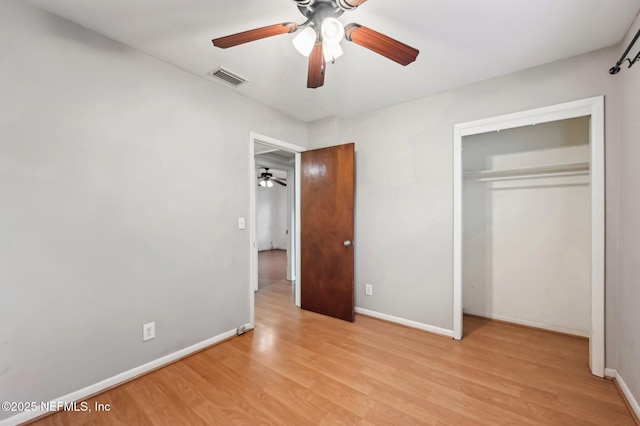 unfurnished bedroom with light hardwood / wood-style floors, a closet, and ceiling fan