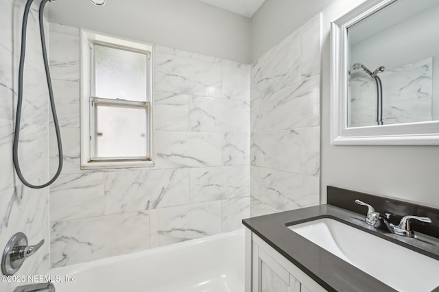 bathroom featuring vanity and tiled shower / bath