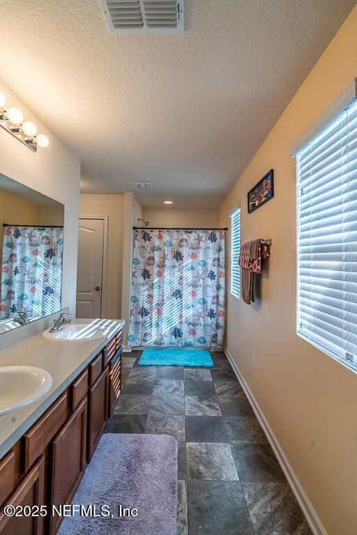 bathroom featuring vanity, a textured ceiling, and a shower with shower curtain