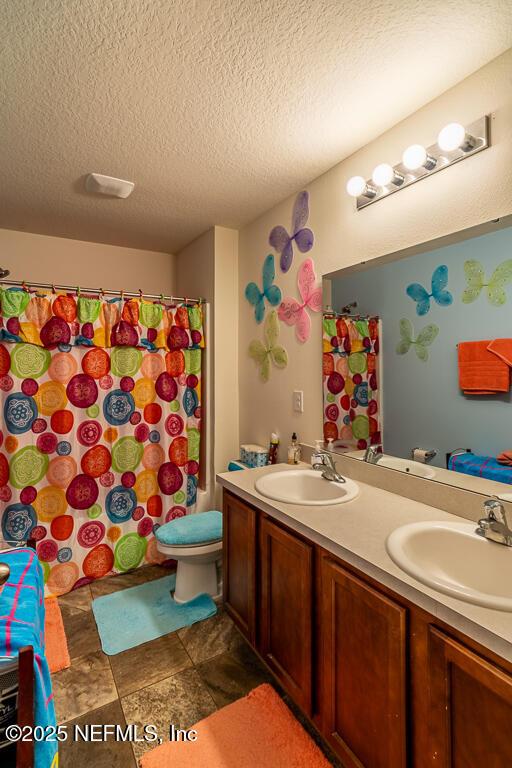 bathroom featuring vanity, toilet, a textured ceiling, and walk in shower