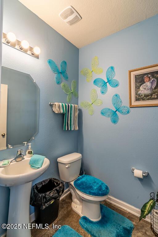 bathroom featuring toilet and tile patterned floors