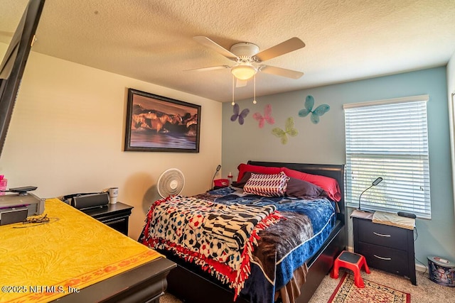 carpeted bedroom featuring a textured ceiling and ceiling fan