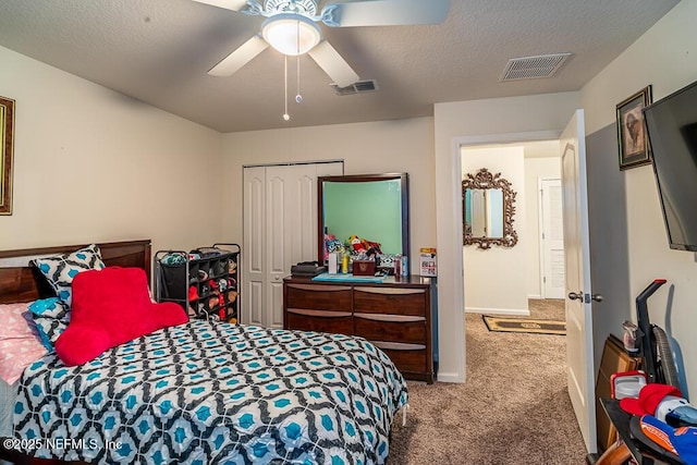 bedroom featuring ceiling fan, a closet, carpet, and a textured ceiling