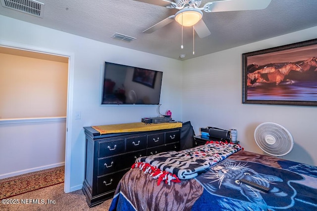 carpeted bedroom with a textured ceiling and ceiling fan