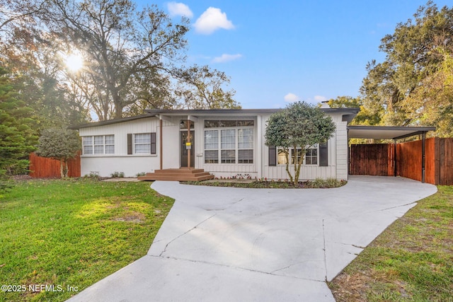 ranch-style home featuring a carport and a front yard