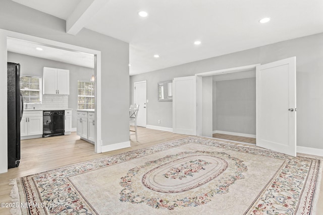 foyer entrance featuring beam ceiling and light wood-type flooring