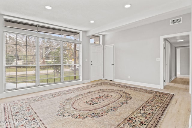 interior space with plenty of natural light and light hardwood / wood-style flooring