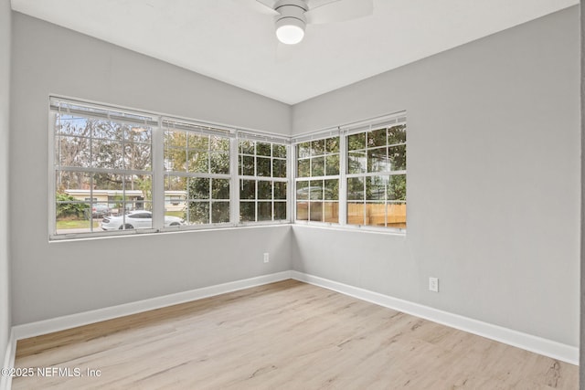 spare room featuring hardwood / wood-style flooring, ceiling fan, and a wealth of natural light