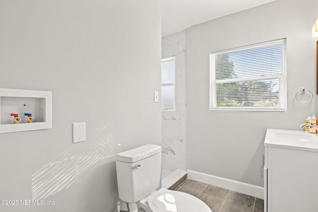 bathroom featuring tiled shower, tile patterned flooring, vanity, and toilet