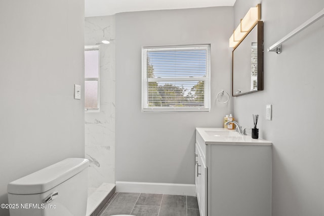 bathroom with vanity, toilet, and a shower