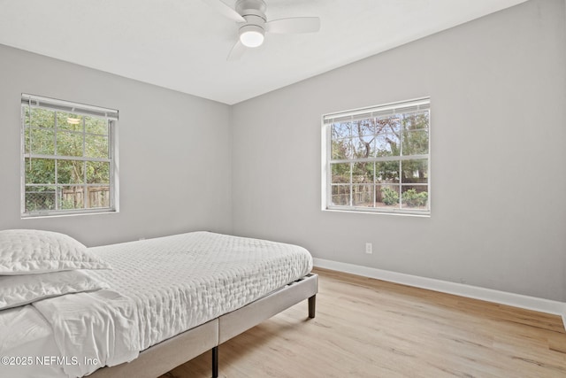 bedroom with multiple windows, ceiling fan, and light hardwood / wood-style flooring