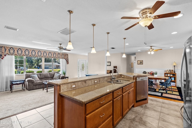 kitchen with pendant lighting, a kitchen island with sink, sink, and appliances with stainless steel finishes