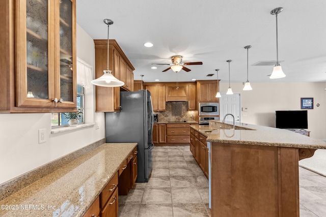 kitchen featuring a kitchen breakfast bar, sink, hanging light fixtures, appliances with stainless steel finishes, and tasteful backsplash