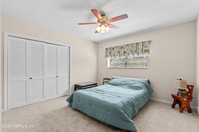 bedroom with carpet, ceiling fan, a textured ceiling, and a closet