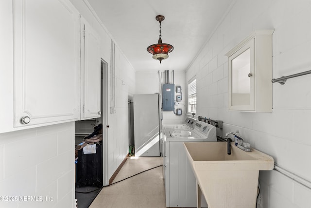 laundry area with cabinets, ornamental molding, sink, separate washer and dryer, and electric panel