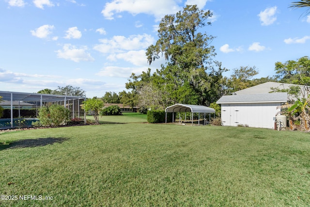 view of yard with glass enclosure and a carport