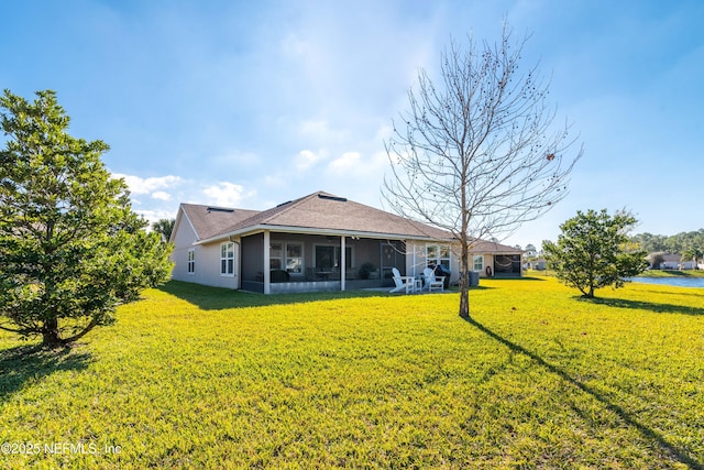 back of property with a yard and a sunroom