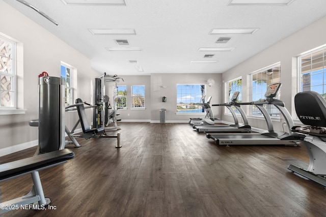 gym with a textured ceiling and dark wood-type flooring