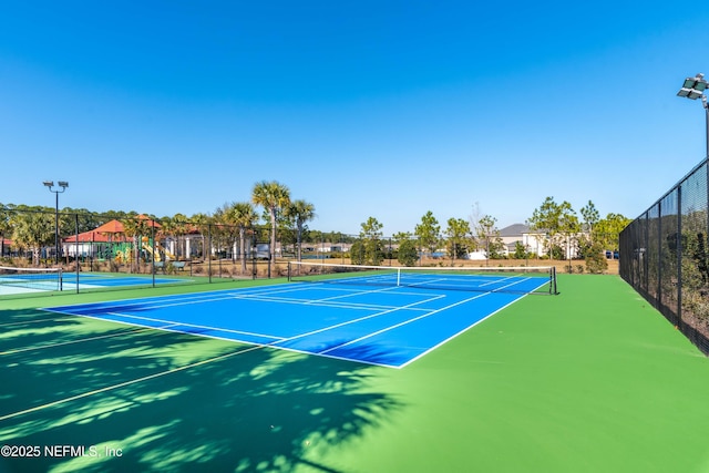 view of tennis court featuring basketball hoop