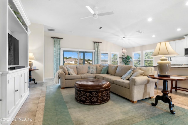 living room with ceiling fan, light tile patterned flooring, and lofted ceiling