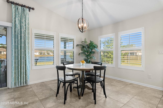 dining area featuring lofted ceiling, light tile patterned floors, and a chandelier