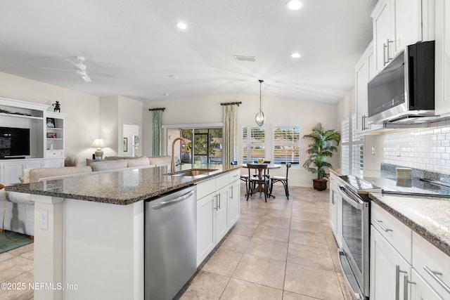 kitchen featuring stainless steel appliances, a kitchen island with sink, sink, white cabinetry, and lofted ceiling