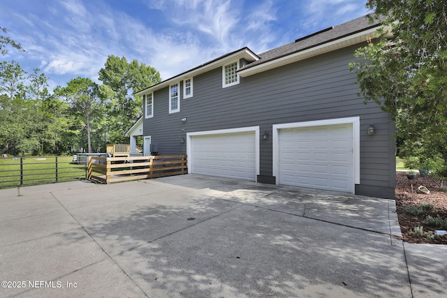 view of property exterior with a garage and a wooden deck