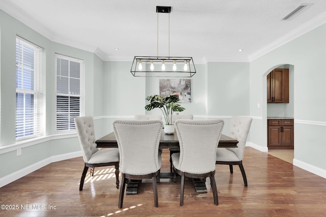 dining room featuring hardwood / wood-style floors, plenty of natural light, and ornamental molding