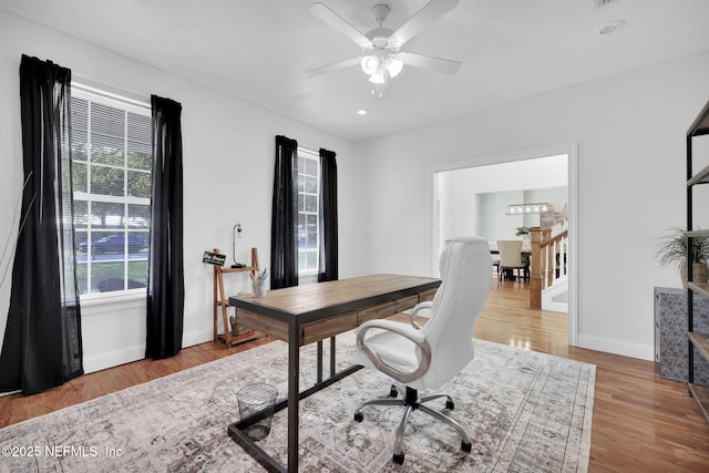 office space with plenty of natural light, light hardwood / wood-style floors, and ceiling fan