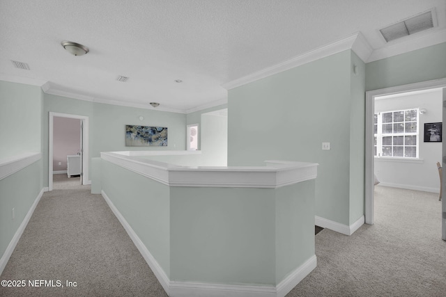 corridor with light carpet, a textured ceiling, plenty of natural light, and crown molding