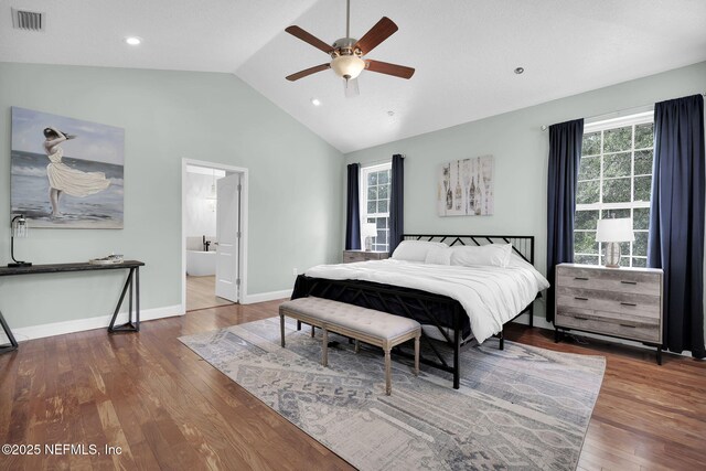 bedroom featuring ceiling fan, ensuite bathroom, lofted ceiling, and hardwood / wood-style flooring