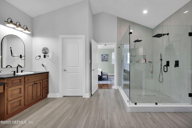 bathroom with a towering ceiling, vanity, and an enclosed shower