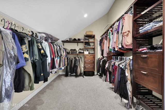 spacious closet with light colored carpet and vaulted ceiling