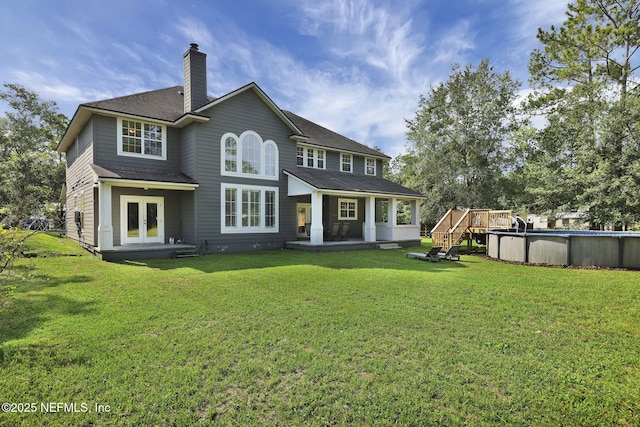 back of house featuring a lawn and french doors