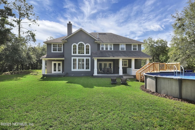 back of property with a yard and french doors