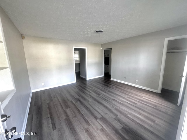 unfurnished bedroom featuring a textured ceiling and dark wood-type flooring