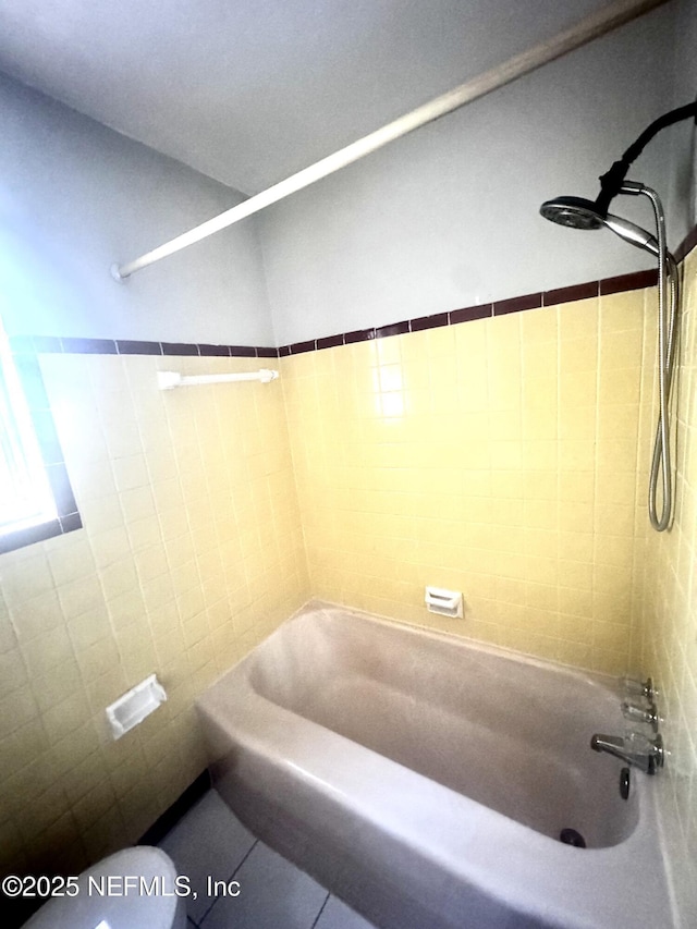 bathroom featuring tile patterned flooring, shower / bathing tub combination, and toilet